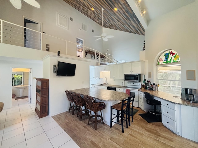 kitchen with white cabinetry, sink, light hardwood / wood-style flooring, and white electric range oven