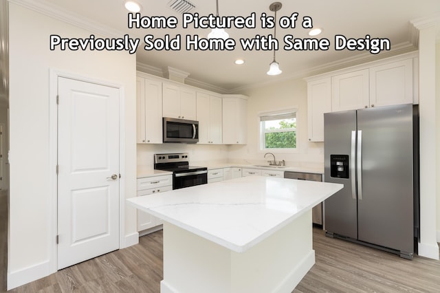 kitchen featuring a sink, light wood finished floors, appliances with stainless steel finishes, and ornamental molding