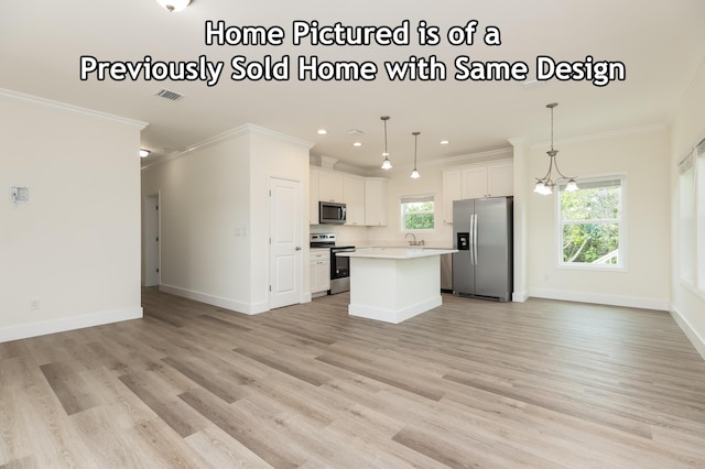 kitchen with open floor plan, appliances with stainless steel finishes, a kitchen island, and ornamental molding