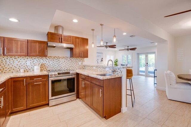 kitchen featuring pendant lighting, sink, a breakfast bar, stainless steel electric stove, and kitchen peninsula