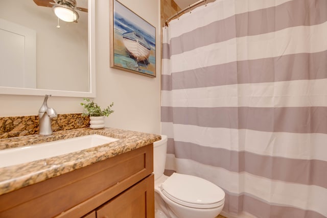 bathroom featuring vanity, curtained shower, ceiling fan, and toilet