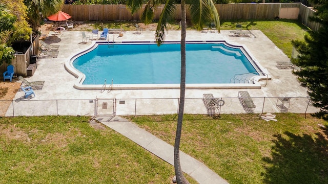 community pool with a patio, a yard, and a fenced backyard