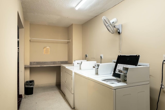 shared laundry area with light floors, washing machine and dryer, and a textured ceiling