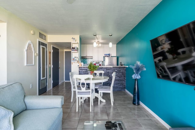 dining area with visible vents, a textured ceiling, baseboards, and tile patterned floors