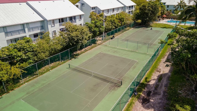 view of sport court featuring fence and a residential view