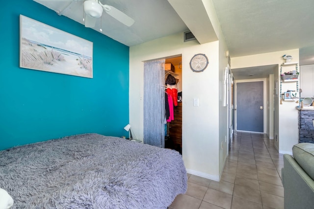 bedroom with a ceiling fan, visible vents, baseboards, and light tile patterned floors