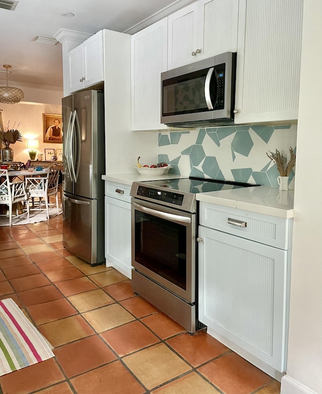 kitchen with backsplash, stainless steel appliances, light tile patterned floors, and white cabinets