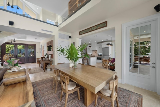 tiled dining area featuring french doors and a towering ceiling