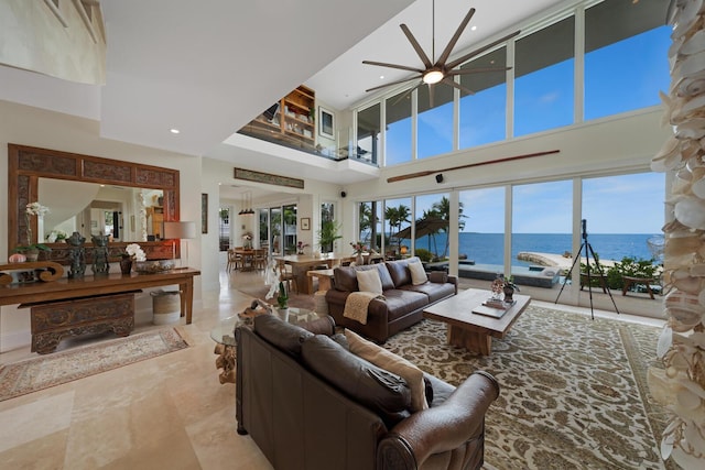 living room with a water view and a towering ceiling