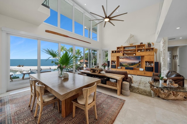 dining room with a towering ceiling and a water view