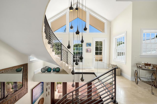 stairway featuring high vaulted ceiling