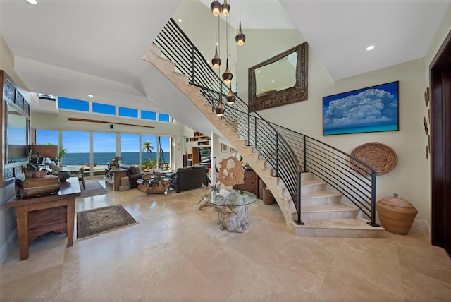 stairs with a high ceiling and a water view