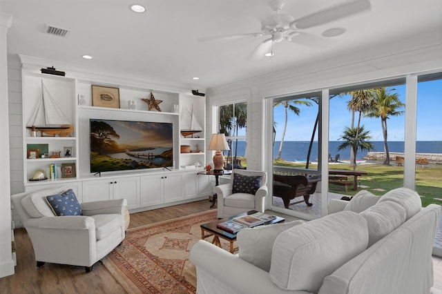 living room with light hardwood / wood-style flooring, built in features, and ceiling fan