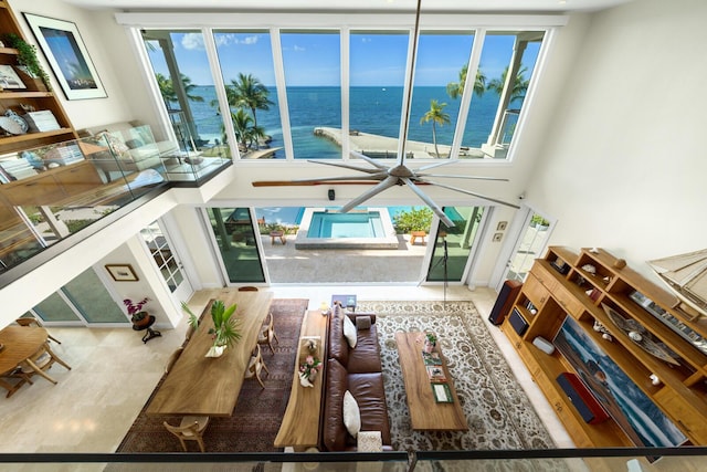 living room with a water view and a high ceiling