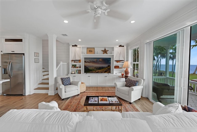 living room featuring light hardwood / wood-style flooring and ceiling fan