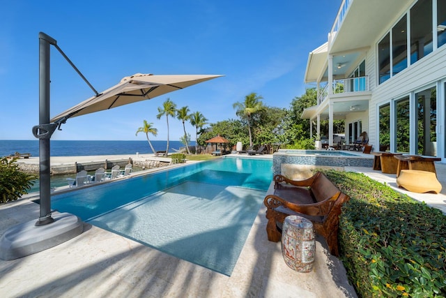 view of pool featuring an in ground hot tub and a water view