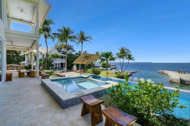 view of pool featuring a water view, an in ground hot tub, and a patio