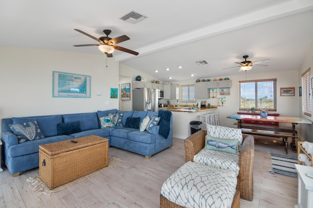 living room featuring lofted ceiling with beams, ceiling fan, and light hardwood / wood-style flooring