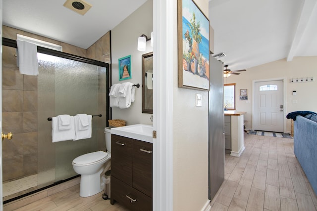 bathroom with ceiling fan, vanity, lofted ceiling with beams, a shower with shower door, and toilet