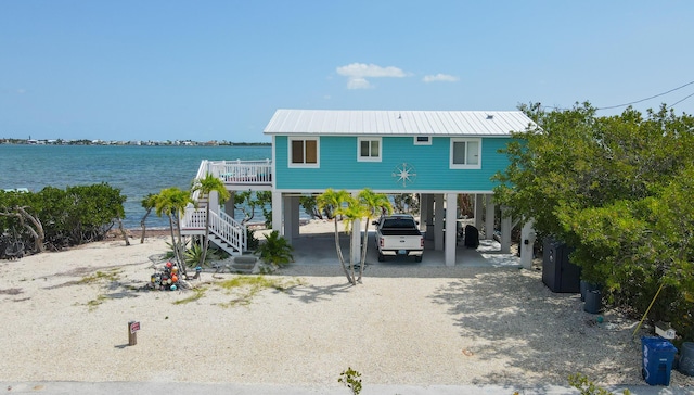 view of front of house with a carport and a water view