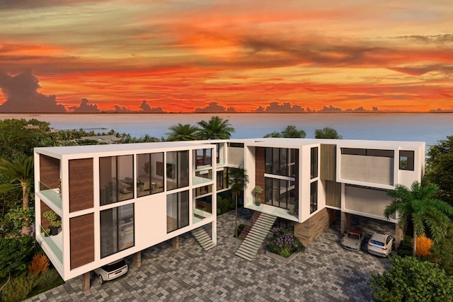 back house at dusk featuring a water view