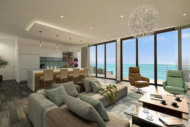 living room with an inviting chandelier, a water view, hardwood / wood-style floors, and a wall of windows