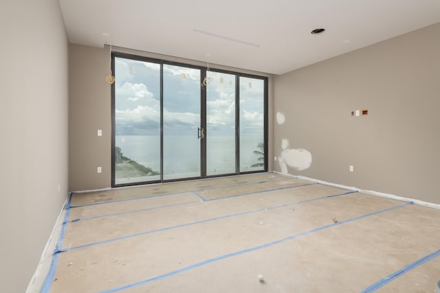 unfurnished room featuring a wall of windows