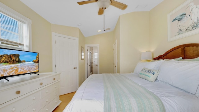 bedroom with light hardwood / wood-style flooring, vaulted ceiling, and ceiling fan