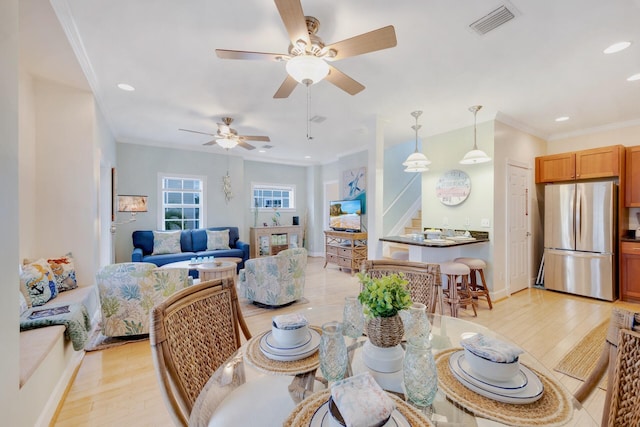 dining space featuring crown molding and light hardwood / wood-style floors