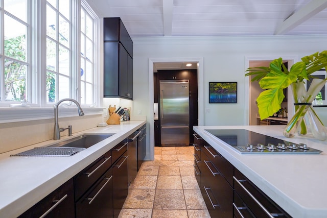 1414 Angela St, Key West, FL 33040 - kitchen with built in refrigerator, black electric stovetop, a sink, light countertops, and stone tile flooring