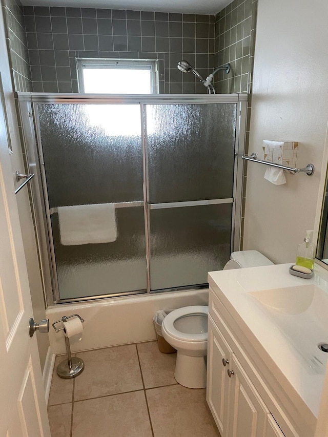 bathroom with bath / shower combo with glass door, vanity, toilet, and tile patterned floors