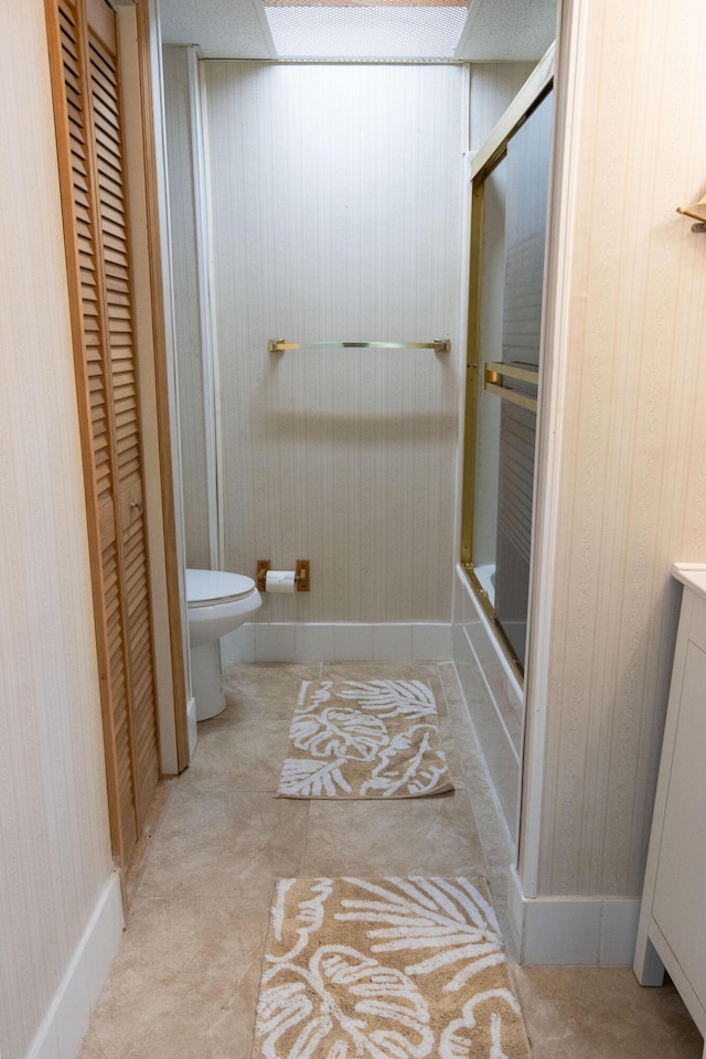 bathroom featuring shower / bath combination with glass door and toilet