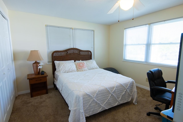 bedroom featuring dark colored carpet, ceiling fan, and a closet