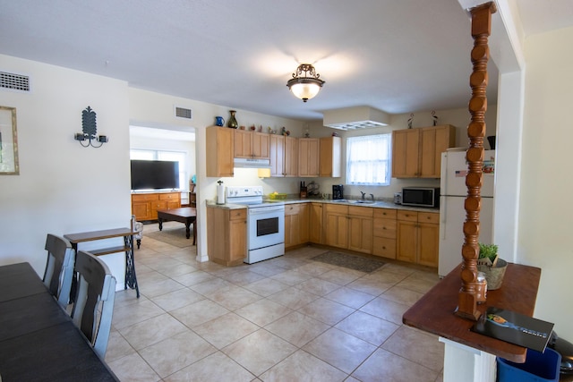 kitchen with sink, white appliances, light tile patterned floors, and light brown cabinets