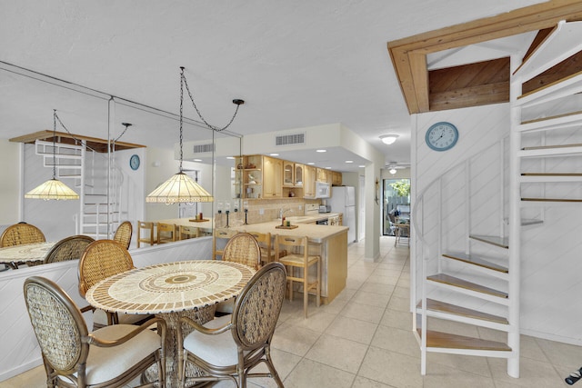 tiled dining area featuring sink and ceiling fan