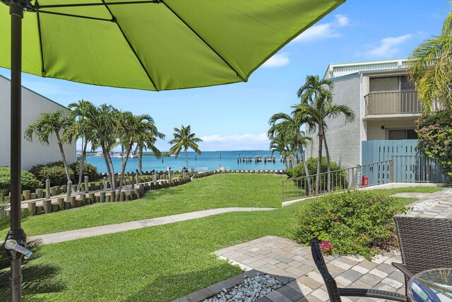 surrounding community featuring a water view and a lawn