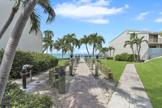 view of home's community featuring a lawn and a water view