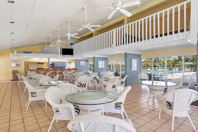 dining room featuring light tile patterned floors and high vaulted ceiling