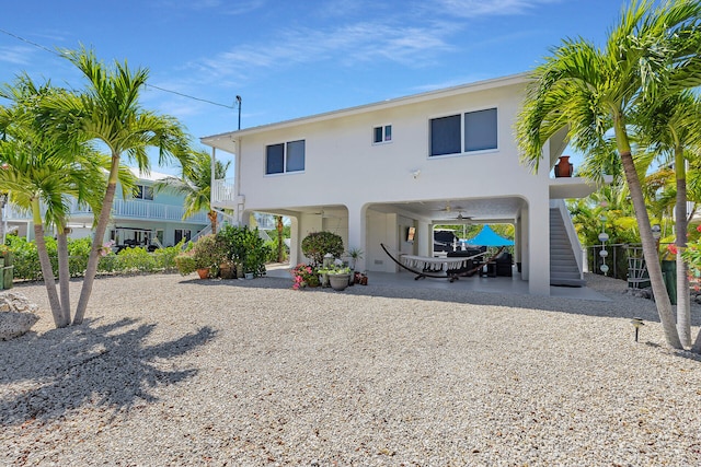 back of property featuring stucco siding and stairs