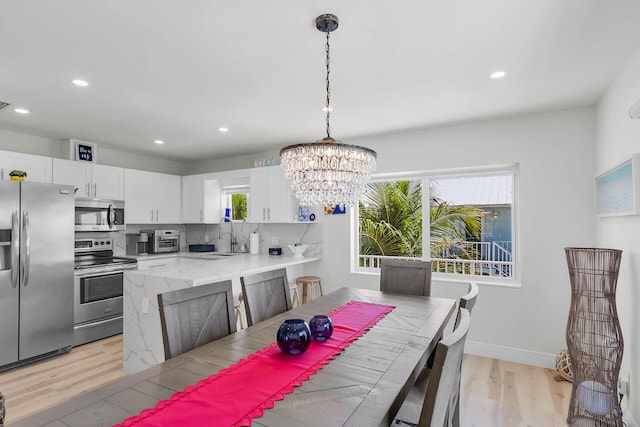 dining room featuring recessed lighting, baseboards, light wood-style floors, and a healthy amount of sunlight