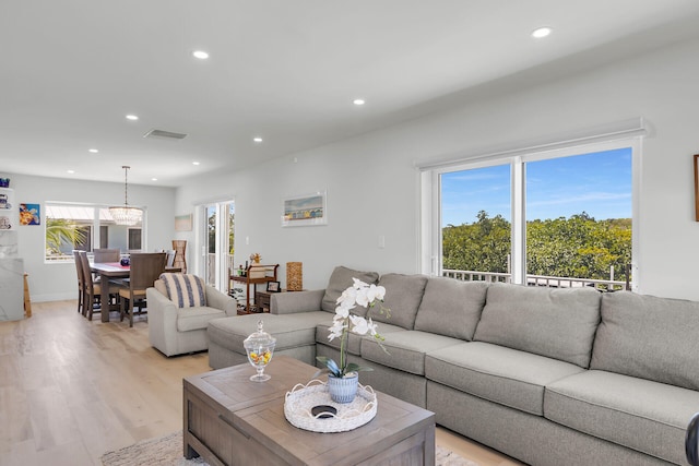 living room with recessed lighting, baseboards, and light wood-style flooring