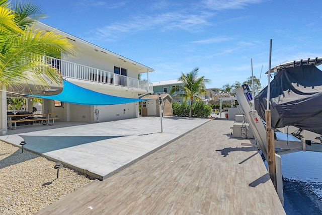 exterior space featuring boat lift, a dock, and a balcony