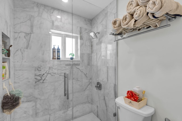 bathroom with a marble finish shower and toilet