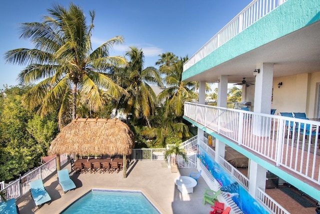 view of swimming pool featuring ceiling fan, an outdoor bar, and a patio