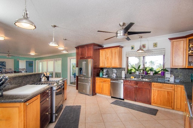 kitchen featuring pendant lighting, sink, light tile patterned floors, appliances with stainless steel finishes, and decorative backsplash