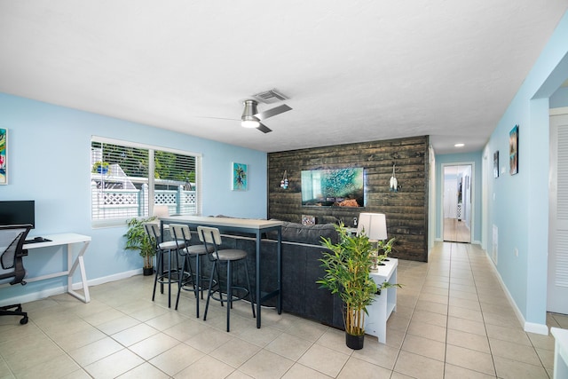 tiled living room with bar and ceiling fan