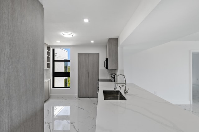 kitchen with marble finish floor, a sink, light stone counters, recessed lighting, and range