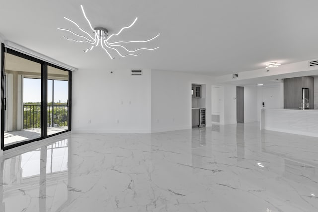 empty room with visible vents, marble finish floor, a wall of windows, and a sink