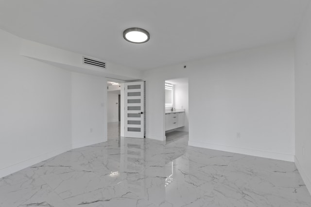 unfurnished room with visible vents, marble finish floor, and baseboards