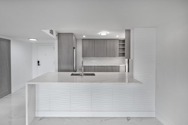 kitchen with light stone counters, open shelves, a sink, modern cabinets, and marble finish floor